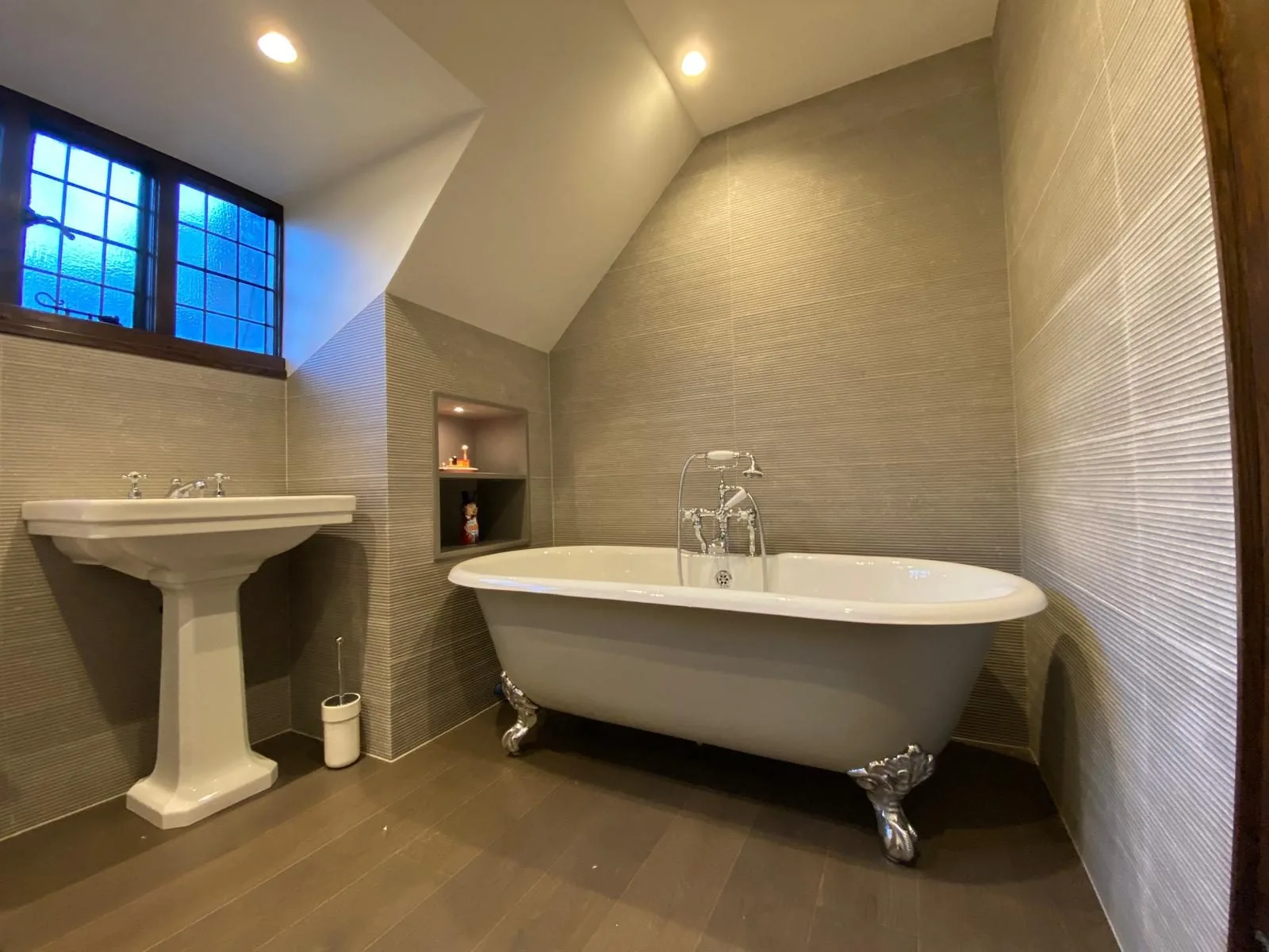 Roll-top bath with traditional shower mixer beside a leaded window, fitted by Pangbourne Plumbing