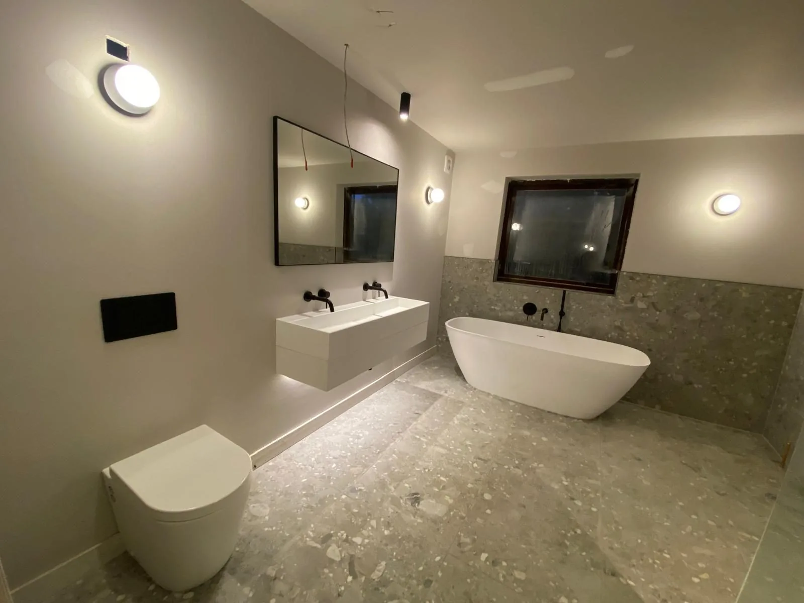 Modern bathroom refit with freestanding bath, floating twin vanity and matt black brassware, fitted by Pangbourne Plumbing