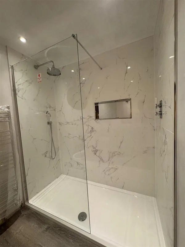Rainfall shower head against marble-effect tiles