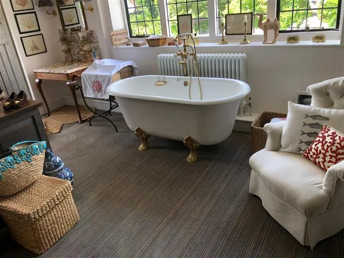 Roll-top bath with brass fittings in a country house bathroom