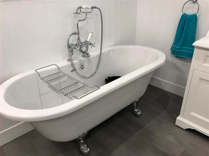 Claw-foot bath with traditional chrome mixer and shower cradle
