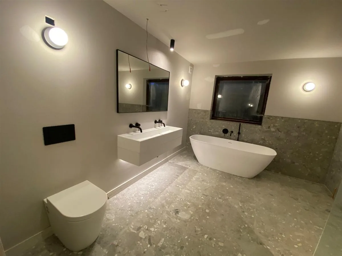 Modern bathroom refit with freestanding bath, floating twin vanity and terrazzo-style tiling