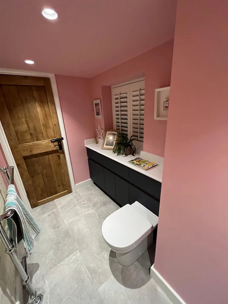 Characterful pink cloakroom with navy vanity and marble-effect floor